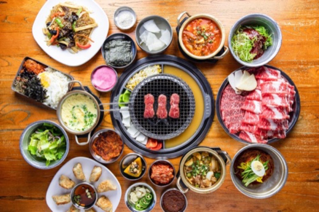 Full Korean BBQ table spread with marinated beef, stews and banchan